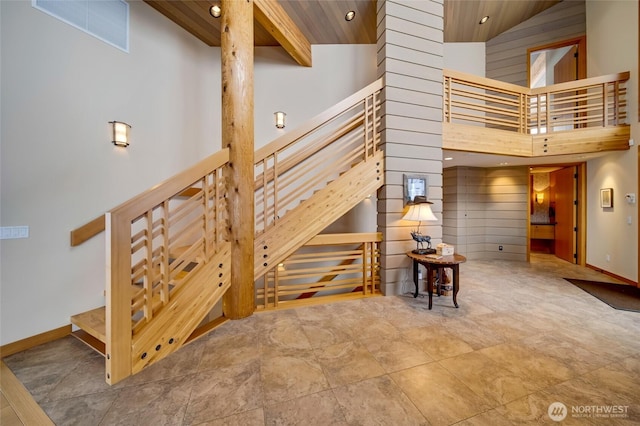 stairway with a towering ceiling, baseboards, and recessed lighting