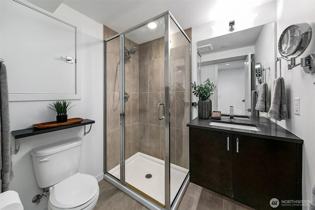 bathroom with toilet, a shower stall, and vanity