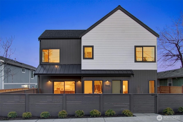 exterior space featuring a fenced front yard, metal roof, a standing seam roof, and a gate