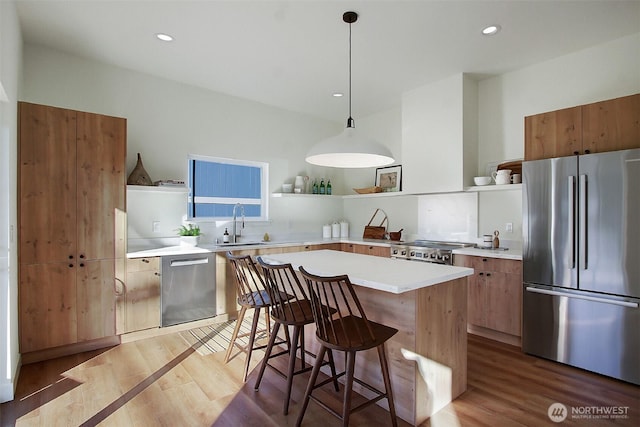 kitchen featuring open shelves, stainless steel appliances, light countertops, light wood-style floors, and a kitchen bar