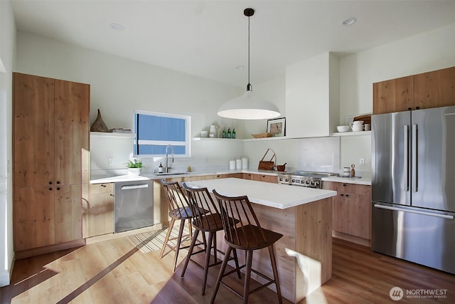 kitchen with a breakfast bar area, light wood finished floors, open shelves, light countertops, and appliances with stainless steel finishes