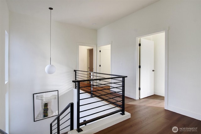 interior space featuring an upstairs landing, baseboards, and wood finished floors