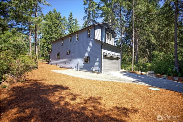 view of side of home with driveway and an attached garage