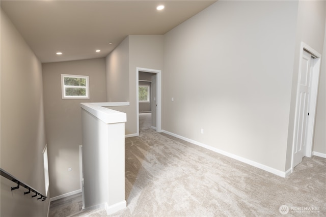 interior space with light carpet, baseboards, vaulted ceiling, and recessed lighting