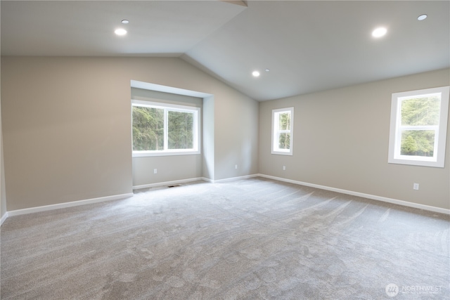 empty room with vaulted ceiling, recessed lighting, light colored carpet, and baseboards