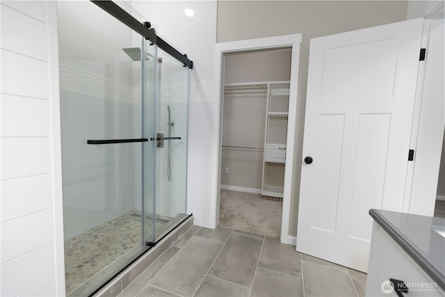 bathroom with a stall shower and tile patterned flooring