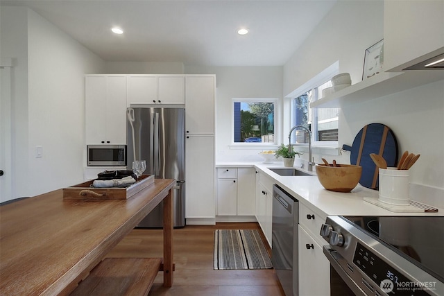 kitchen featuring white cabinets, appliances with stainless steel finishes, open shelves, and a sink