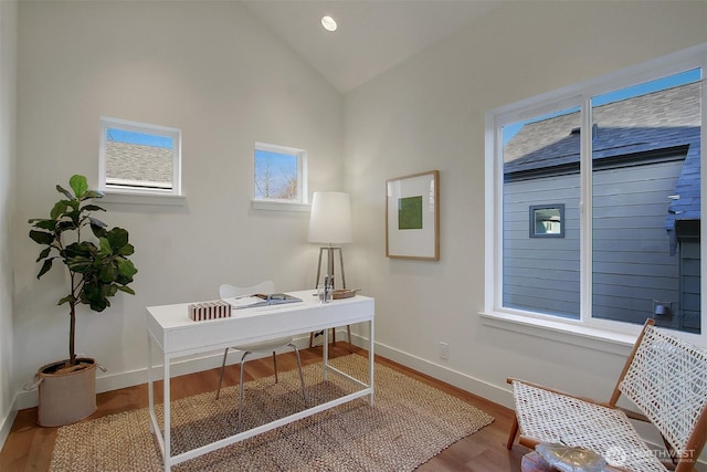 office area with wood finished floors, baseboards, and vaulted ceiling