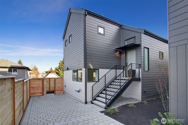 rear view of house with a patio area and fence