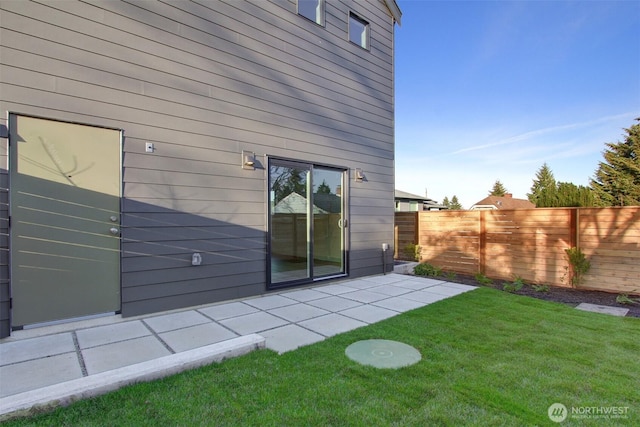 rear view of property featuring a patio area, a lawn, and fence