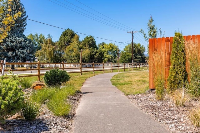 view of home's community with fence and a yard