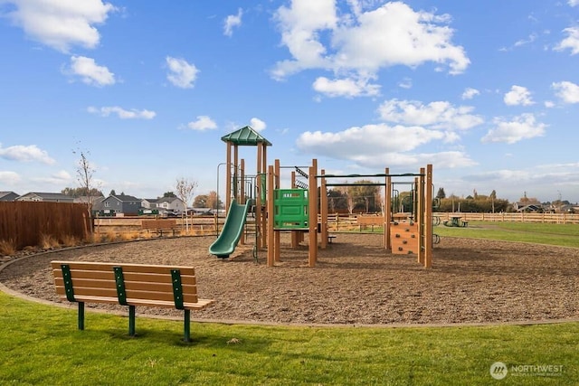 communal playground featuring fence and a yard