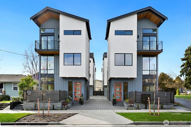 modern home with a balcony and board and batten siding