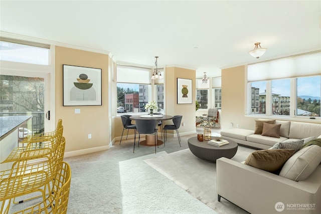 living room featuring ornamental molding, light colored carpet, a healthy amount of sunlight, and baseboards