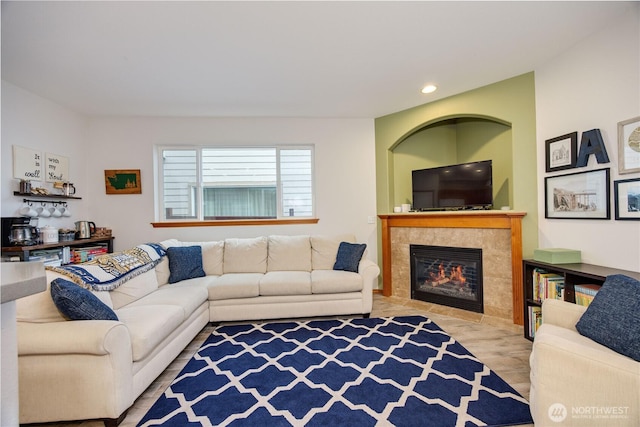 living room with wood finished floors, a tile fireplace, and recessed lighting