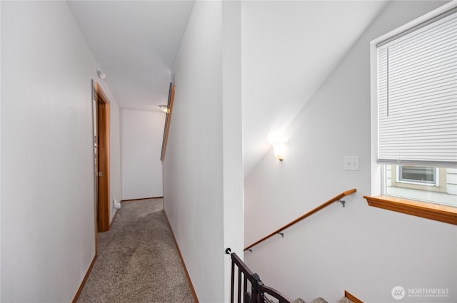 hall featuring carpet floors, an upstairs landing, and baseboards