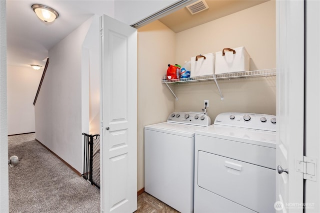 washroom featuring light carpet, laundry area, washer and clothes dryer, and visible vents