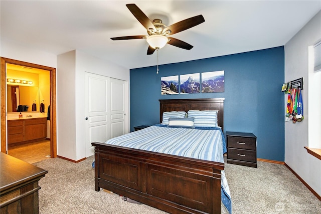 bedroom featuring carpet, a closet, ensuite bathroom, a ceiling fan, and baseboards