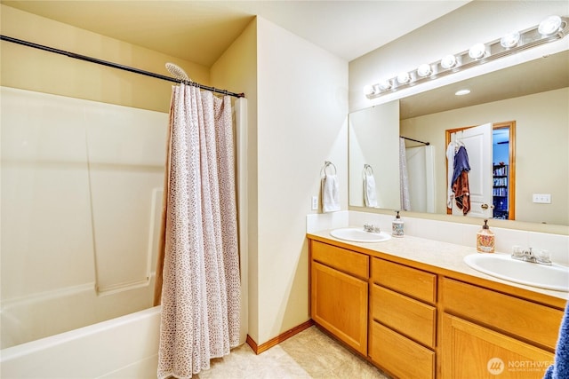 bathroom featuring double vanity, baseboards, a sink, and shower / tub combo with curtain