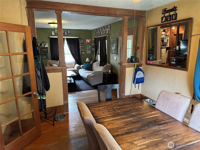 4700 Delta Ln SE, Tumwater, WA 98501 - dining space with a textured wall, hardwood / wood-style flooring, a textured ceiling, and ornate columns