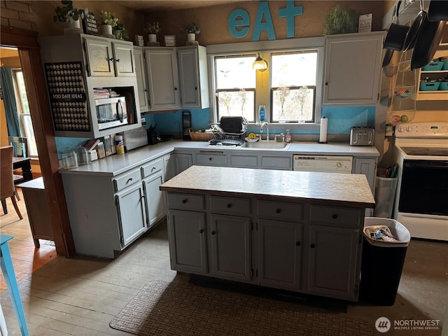 4700 Delta Ln SE, Tumwater, WA 98501 - kitchen featuring white appliances, light countertops, a sink, light wood finished floors, and a kitchen island