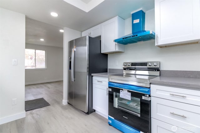 kitchen with light wood-type flooring, recessed lighting, stainless steel appliances, white cabinetry, and wall chimney exhaust hood