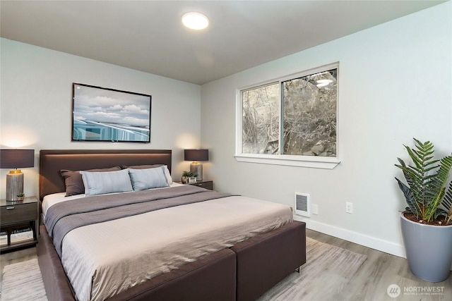 bedroom featuring baseboards, visible vents, and light wood-type flooring