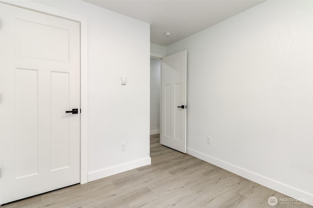 unfurnished bedroom with light wood finished floors and baseboards