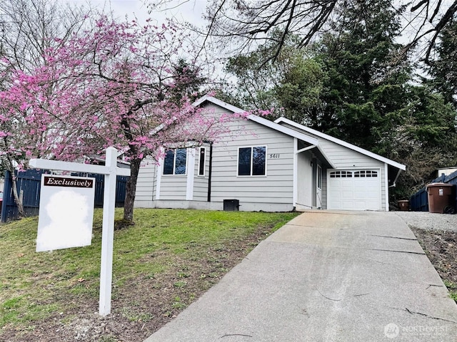 ranch-style house with a front lawn, concrete driveway, and a garage