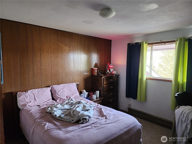 carpeted bedroom featuring wood walls, baseboards, baseboard heating, and a textured ceiling