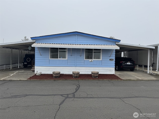 manufactured / mobile home featuring an attached carport and concrete driveway