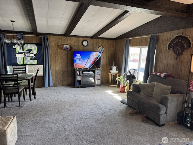 carpeted living area featuring a notable chandelier, wood walls, and lofted ceiling with beams