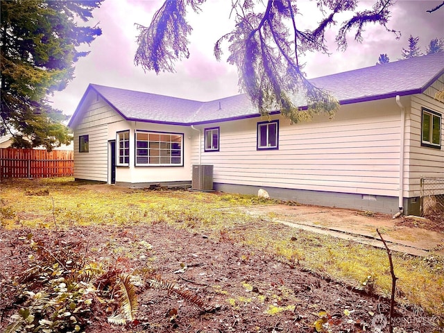 rear view of property featuring a shingled roof, crawl space, central AC, and fence