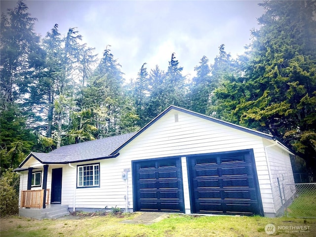 garage with driveway and fence