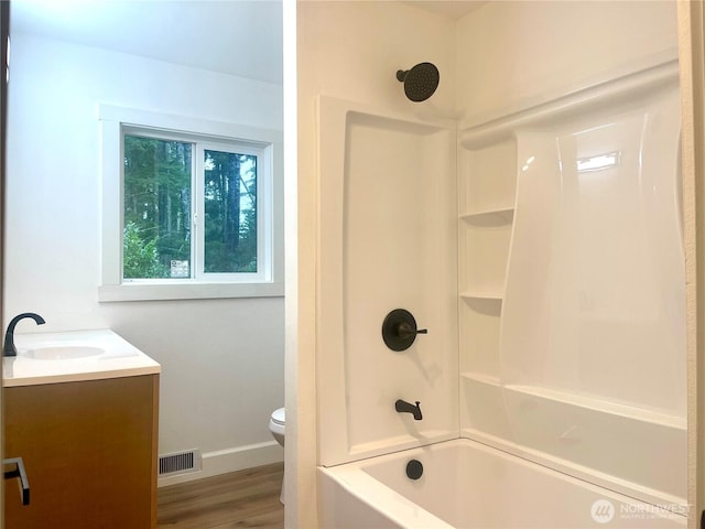 full bath featuring visible vents, toilet, tub / shower combination, vanity, and wood finished floors