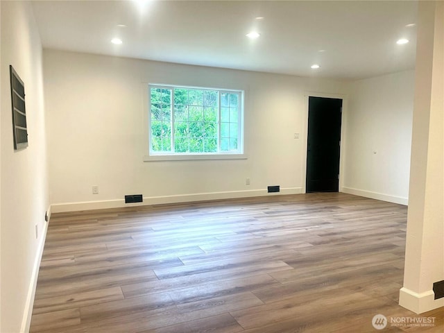 empty room featuring baseboards, light wood finished floors, visible vents, and recessed lighting