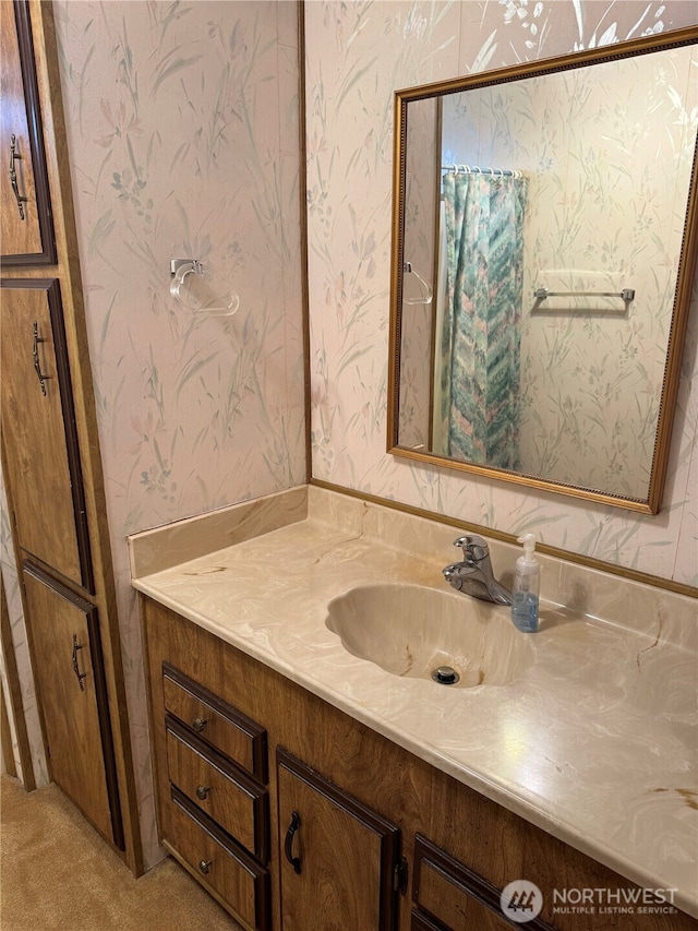 bathroom with vanity and wallpapered walls