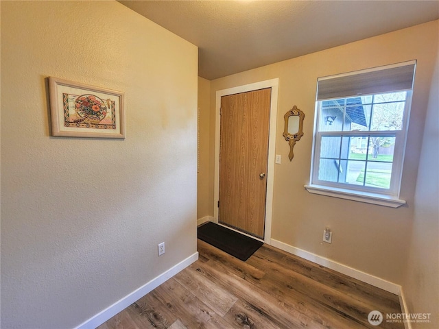 foyer featuring wood finished floors and baseboards