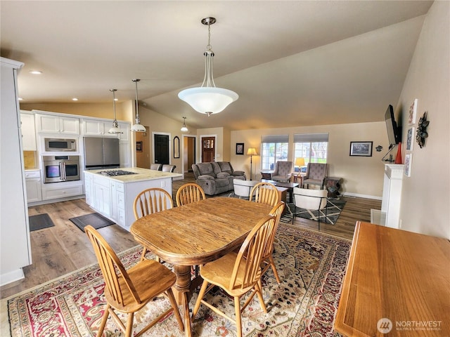 dining room featuring recessed lighting, baseboards, vaulted ceiling, and light wood finished floors