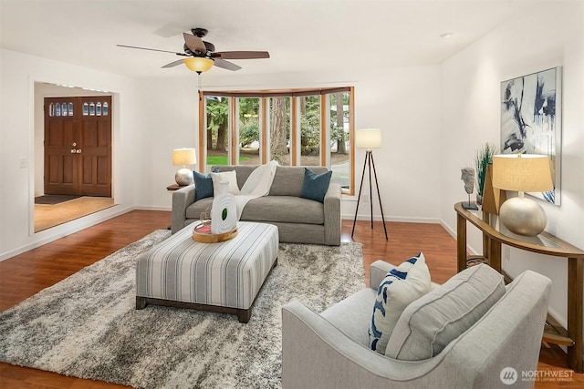 living area featuring a ceiling fan, wood finished floors, and baseboards