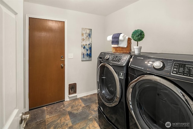 laundry room featuring stone tile floors, laundry area, baseboards, and separate washer and dryer