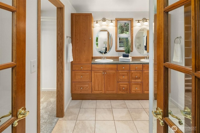 bathroom with tile patterned flooring, double vanity, and a sink