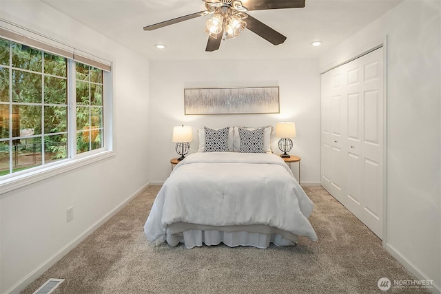 bedroom with a closet, visible vents, baseboards, and carpet floors