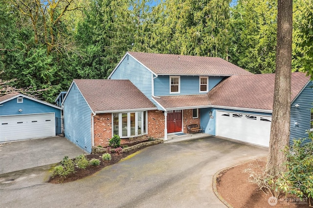 traditional-style house with aphalt driveway, brick siding, an attached garage, and a shingled roof