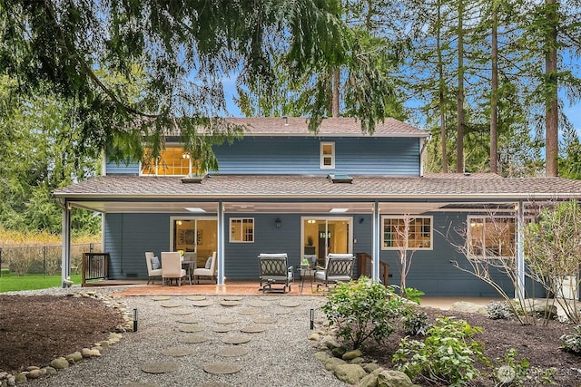 back of house with a shingled roof and fence