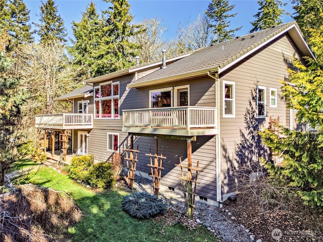 back of property with a yard, crawl space, and a wooden deck