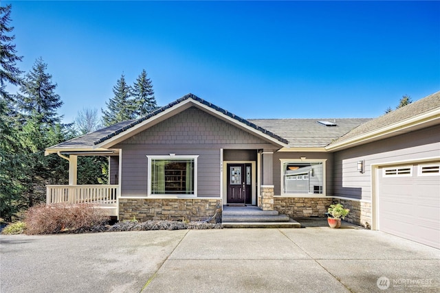 craftsman inspired home featuring stone siding and concrete driveway