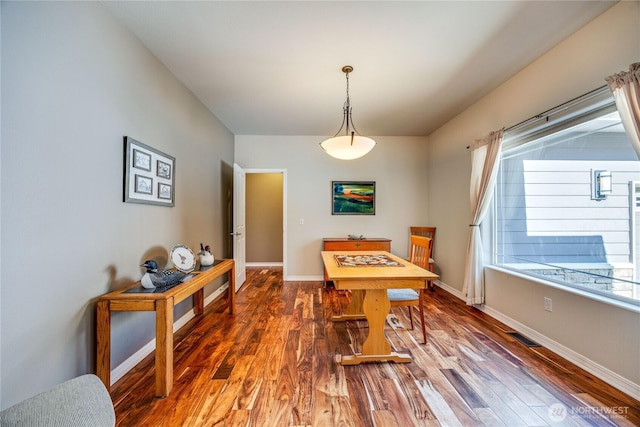 dining space featuring baseboards and wood finished floors