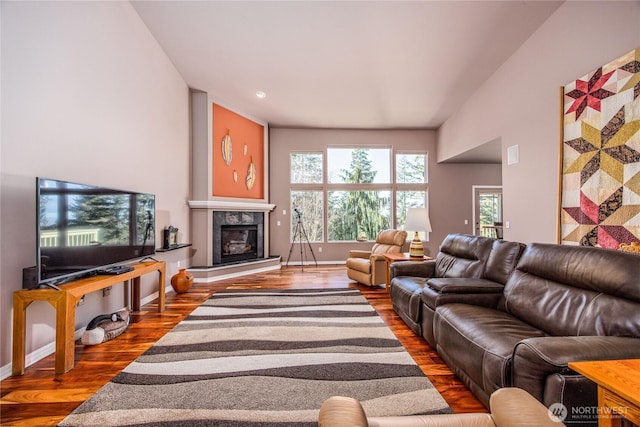 living room featuring a fireplace, wood finished floors, and baseboards