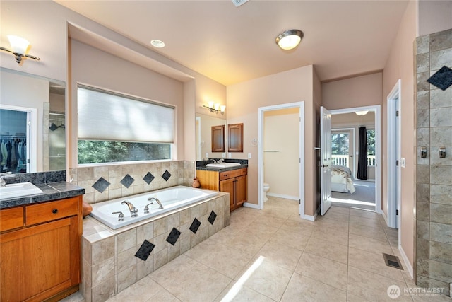 bathroom with tile patterned flooring, a garden tub, toilet, vanity, and tiled shower